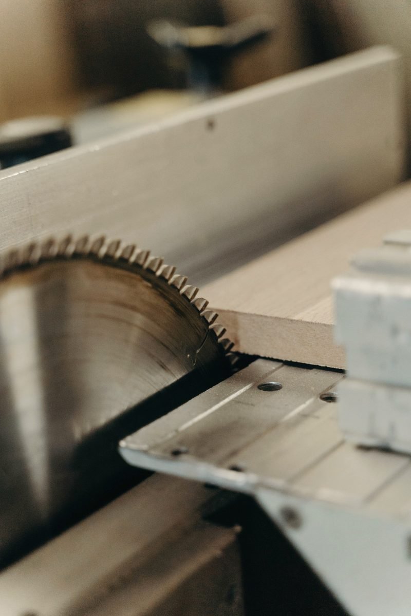 A circular saw blade set into a saw table beside a board.