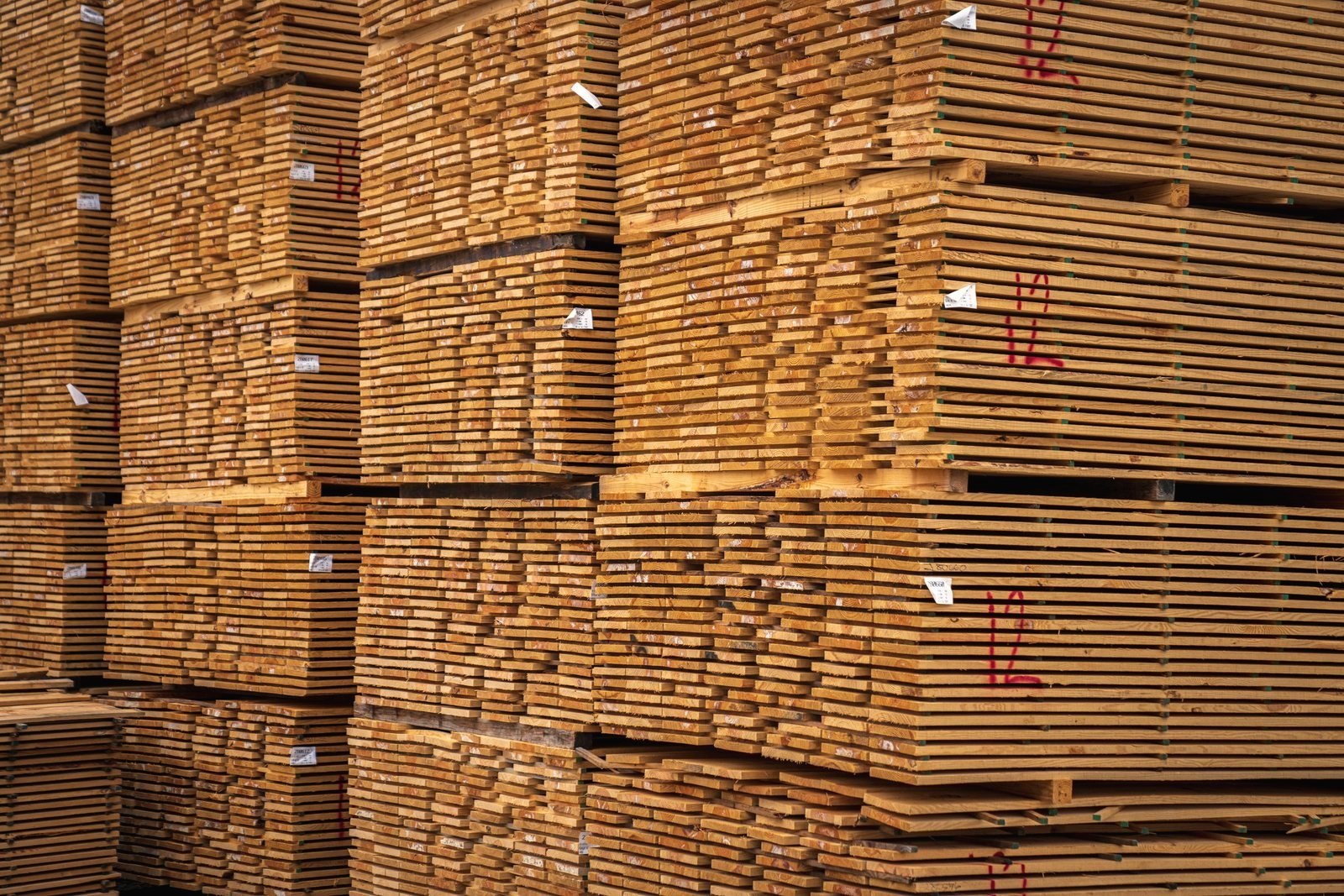 Close view of the sawn ends of stacked boards, sticker-separated in the pile.