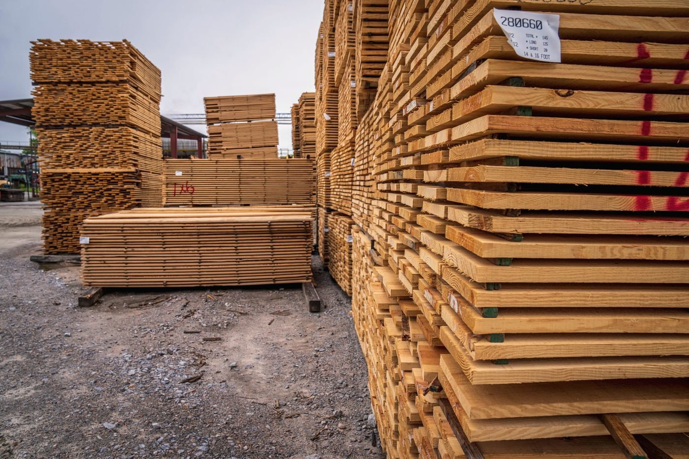 An aisle between two rows of banded lumber units in a working yard.